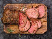 roast-beef-on-cutting-board-with-salt-and-pepper-top-view